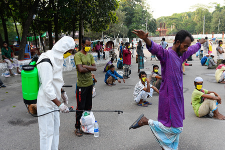 A volunteer wearing a protective suit disinfects a homeless man as a preventive measure during the Coronavirus (COVID-19) crisis.
Volunteers from Dhaka University campus donate relief food and offer free medical support to the vulnerable people amid coronavirus crisis.