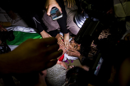 (EDITORS NOTE: Image depicts death.) Mourners seen touching the face of Palestinian citizen Karim Kalab who was killed during a demonstration near the border between Israel and Gaza.