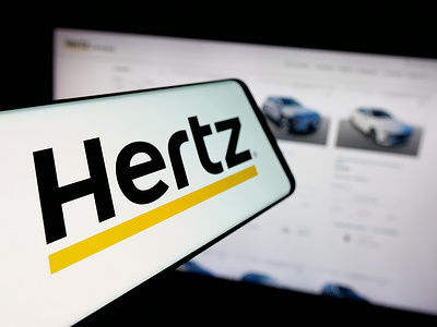In this photo illustration, a smartphone with the logo of car rental company Hertz Global Holdings Inc. is seen on screen in front of website.