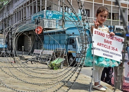 A Kashmiri girl seen holding a placard as she stands next to a concertina wire during the protest.
Life in Kashmir valley came to a standstill due to a complete shutdown called by the Joint Resistance Leadership (JRL) against the legal challenge in the Supreme Court on the validity of Article 35-A, which bars people from outside Jammu and Kashmir from acquiring any immovable property in the state. Traders staged a sit-down at the historic clock tower in Lal Chowk to protest the "legal onslaught" on the Article 35-A. Protestors carrying placards shouted pro-freedom slogans and warned of serious consequences if Article 35A is removed.