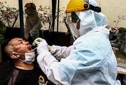 A health worker wearing a personal protective equipment suit (PPE) takes a mouth swab sample from a man in Medan.Medical workers in Medan, carry out Covid-19 testing in an effort to curb the accelerating coronavirus outbreak. The Health Ministry announced 3,535 new confirmed COVID-19 cases on Monday, bringing the total number of infections nationwide to 470,648. According to data released by the ministry on Monday, 85 more people have died of the disease, bringing the death toll to 15,296.