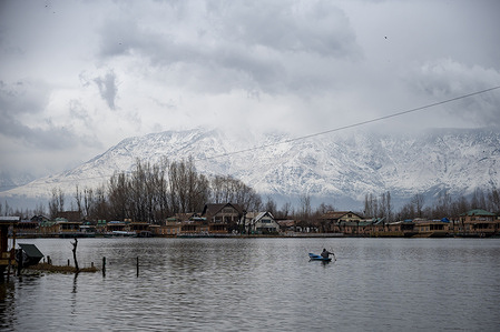 A man rows his boat past snow-covered mountains amid windy conditions in Srinagar. Severe winter weather battered Jammu and Kashmir as fresh snowfall, heavy rain and powerful winds disrupted normal life across the Union Territory. Authorities issued a high-danger avalanche warning for six districts, while parts of Srinagar received the season’s first snowfall. Windstorms caused widespread damage to homes, triggered power outages, halted air traffic, and raised the risk of avalanches and landslides in vulnerable areas.