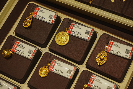 Exquisite gold pendants with price tags from Zhou Da Sheng, exhibited at a Times Mall jewelry shop. International gold futures and spot prices surged past the last price, from $5,200 to $5,300 per ounce, setting fresh all-time highs.