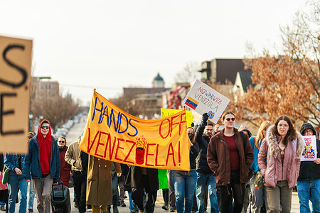 Demonstrators carry a banner reading “Hands Off Venezuela!” during a protest opposing the United States’ military intervention in Venezuela. Dozens of residents gathered on the lawn of the Monroe County courthouse in Bloomington, Indiana, for a “Hands Off Venezuela” rally protesting the U.S. military operation that captured Nicolás Maduro.