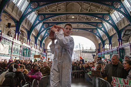 A butcher parades a joint of meat during the annual Smithfield Market Christmas Eve auction. Members of the public attend the annual Smithfield Market Meat Auction. Held every Christmas eve, the tradition organised by individual suppliers, butchers and porter’s auction off surplus prime cuts of meat at a reduced price. The 900-year-old market situated in the City of London faces an uncertain future as the site has been marked for re-development with the market being moved to another of part of London.