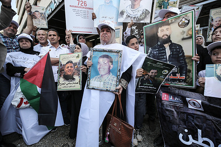 Palestinian protesters hold signs as they gather to demand the return of the bodies of their slain relatives held by Israeli forces.