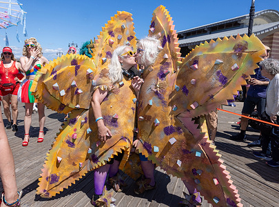A couple dressed as starfish seen walking the famous boardwalk. Thousands attend the 44th Annual Coney Island Mermaid Parade 2026 which kicks off the summer in the city.