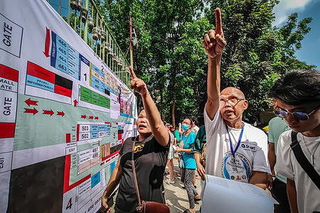 Voters find their names and precinct numbers at a polling site before casting their votes for the Philippine midterm elections in Antipolo City. Antipolo City in Rizal Province, the largest in the CALABARZON Region with a population of 989,859 and 482,062 registered voters (2019), participated in the Philippine midterm elections held on May 12, 2025.