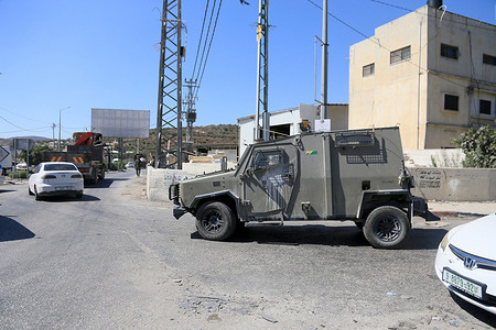 An Israeli military jeep guards a street near a military checkpoint following a car-ramming attack carried out by a Palestinian near an Israeli military base south of the city of Jenin. Israeli troops fired upon a Palestinian vehicle east of Jenin, killing one occupant and wounding a second following an alleged car-ramming attempt near a military post. Following the fatal incident, the Israeli army established a security cordon and blocked main transit routes connecting Jenin to surrounding areas.
