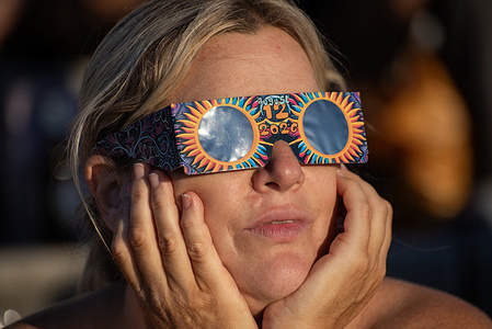 A woman seen enjoying the solar eclipse using her glasses. Hundreds of people gathered on the King's Steps to enjoy the partial solar eclipse in Margate, UK. Because of the Sun was covered by the Moon 90.6% on the maximum phase of the partial solar eclipse.