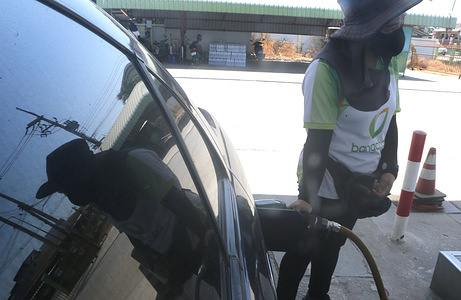 A Thai worker is refueling the customer's vehicle at a gas station in Nakhon Sawan province, north of Bangkok.