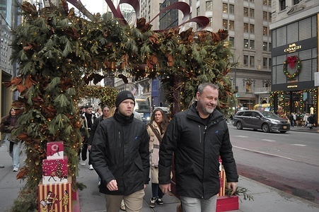 People walk past Christmas decorations on Fifth Avenue.