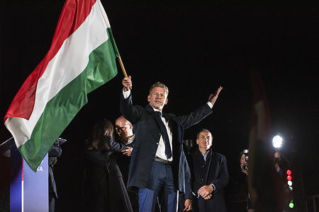 Peter Magyar waves the Hungarian flag after his speech during the TISZA party's election night event in Budapest. April 12, 2026, marked the most significant political transformation in Hungary in decades. The election night for Peter Magyar's TISZA party in Budapest saw thousands of citizens gathering to celebrate a decisive victory over Prime Minister Viktor Orbán’s Fidesz party, which had been in power since 2010.
Péter Magyar, who emerged as a central opposition figure only two years ago, successfully mobilized a record number of voters by focusing his campaign on anti-corruption measures, improving living standards, and restoring Hungary's pro-European course.