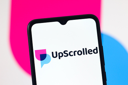 In this photo illustration, the UpScrolled (Up Scrolled) logo is seen displayed on a smartphone screen.