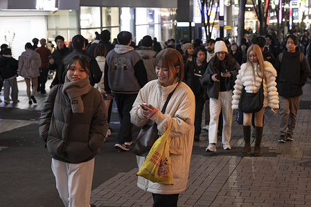 Pedestrians walk down a street inside the amusement district of Shinjuku.
