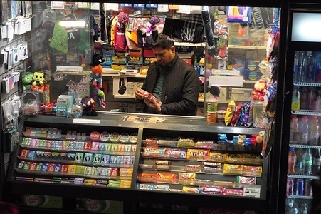 A person stands inside a vendor stand in Manhattan, New York City.