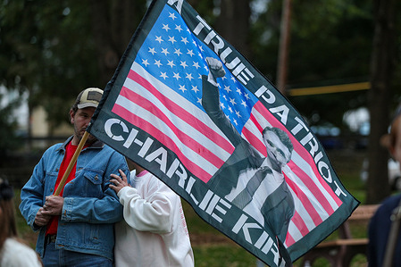 Josh Sickora holds a flag depicting Charlie Kirk during a memorial service for Kirk at Danville's Memorial Park. People gathered in Danville's Memorial Park for a memorial service for right-wing political activist Charlie Kirk.