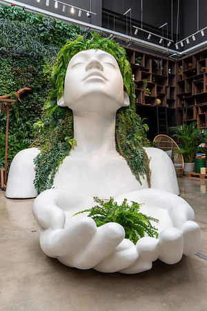 A bust sculpture of a woman decorated with ferns and tropical plants, holding a small plant in its hands, is displayed at Sama Garden in Bangkok. Sama Garden is a plant-focused lifestyle hub in Bangkok promoting green living and community activities at BITEC (Bangkok International Trade & Exhibition Centre) in Bangkok.
