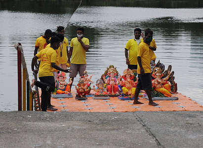 Volunteers wearing protective masks carry idols of Hindu god Ganesh for immersion during the last day of the festival.
'Anant Chaturdashi' or the last day of the Ganpati festival signifies the return of god to Mount Kailash to join his parents Lord Shiva and Goddess Parvati. It also denotes the significance of the cycle of birth, life and death. The idol of Ganesh is immersed in free flowing water, either in a river or a sea.