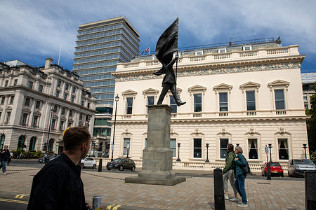 People walk past a suspected Banksy art work in Central London. In the early hours, a 25-foot statue appeared on Waterloo Place in St James’s, Mayfair. The work is attributed to Banksy, though no official confirmation was issued. The structure appears to have been assembled overnight using prefabricated sections and was signed “Banksy” at its base. By morning, passersby began gathering to take photographs as awareness spread about the artwork and its location.