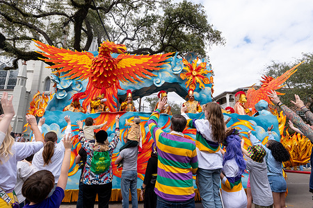 Riders on a Krewe of Rex float toss throws to revelers as the Mardi Gras parade rolls down St. Charles Avenue in New Orleans. mardi gras, fat tuesday, new orleans, carnival, nola, rex, krewe, krewe of rex, king of mardi gras, garden district, st. carles, parade, parades, neutral ground, marching band
