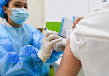 A health worker administers a dose of Sinopharm COVID-19 vaccine to a man.At the vaccination clinic of Gulou community health service center, medical staff prepare to vaccinate the citizens with the inactivated covid-19 vaccine of Sinopharm group. According to the National Health Protection Commission of China, as of June 14, 2021, 31 provinces (autonomous regions and municipalities) and the Xinjiang production and Construction Corps reported 904 million 134 thousand doses of COVID-19 vaccine.