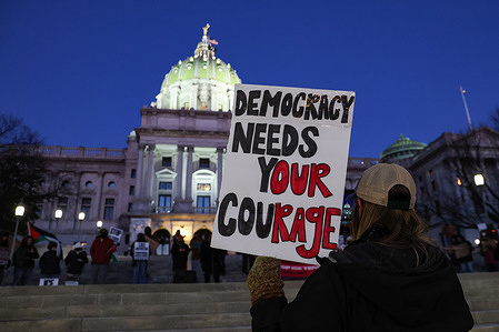 A protester holds a placard during the nationwide "Stop ICE Terror" rally at the Pennsylvania State Capitol against the U.S. President Donald Trump's policies.