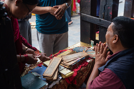 Devotees taking blessings from a priest in Gunla Parva, a month-long festival, at Swayambhunath Stupa. Gunla is a sacred month-long festival celebrated by Newar Buddhists in the Kathmandu Valley. It marks the tenth month of the Nepal Sambat calendar. Devotees visit monasteries, play traditional musical instruments, and walk around stupas.