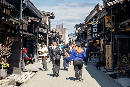 Visitors walk along a traditional street lined with preserved wooden merchant houses in the Sanmachi Suji historic district in Takayama, Gifu Prefecture, Japan. Sanmachi Suji is Takayama’s historic district, known for its preserved Edo-period streets lined with wooden merchant houses and sake breweries. The area offers a glimpse into traditional Japanese life, with narrow lanes, local shops, and a distinctly old-world atmosphere.