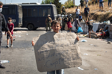 A young child is seen displaying a protest placard on Lesbos island in wake of a fire at Moria camp.
More than 13,000 Asylum seekers flee fire at Greece's largest migrant Moira camp at lesbos. They have been stranded on the street before the town of mitilini and prevented to enter the harbour by police.