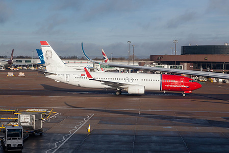 A Norwegian Airlines Boeing 737-800 with a portrait of Sonja Henie on the tailplane at Heathrow Airport.