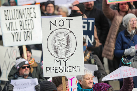 Protesters hold placards outside of the Pennsylvania Capitol during a 50501 protest. The 50501 Movement planned to hold 50 protests in 50 states on one day to protest Trump administration policies and Project 2025.