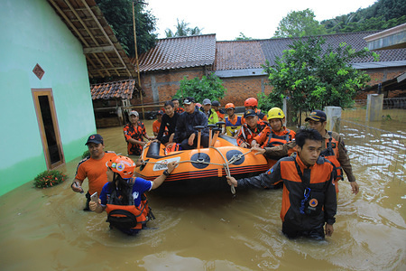 The Mayor of Bogor, Bima Arya (C) was seen monitoring the evacuation process of residents with rubber boats. Dozens of residents were evacuated due to the flood disaster that hit village Rancamaya Cikobak RT 03/04, Rancamaya, Bogor City. This flood began to hit dozens of houses in Kampung Rancamaya Cikobak due to the flow of the Cisadane tributary of the Cimakaci River overflowing.