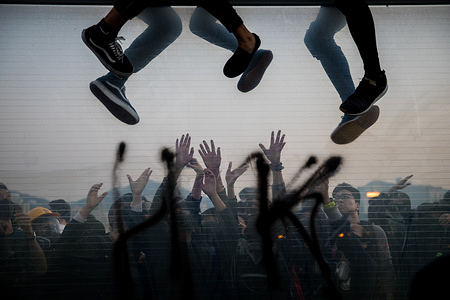 Protesters climbing over a highway dividers fleeing from police arrests as their comrades help on the other side during a demonstration. 
Hong Kong's anti-extradition bill protests continue.