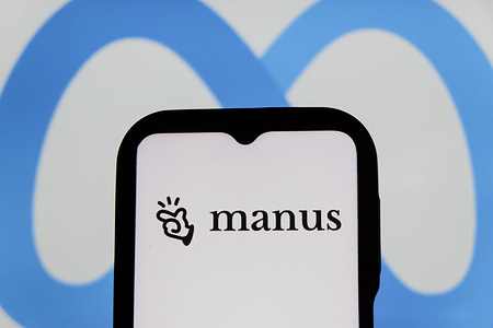 In this photo illustration, the Manus AI logo is seen displayed on a smartphone screen and the Meta logo in the background.