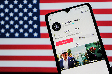 In this photo illustration, the official TikTok account of the White House in the United States seen displayed on a smartphone with Flag of America in the background.