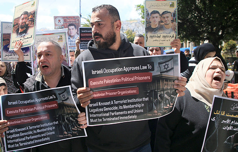 Palestinians hold up placards during a demonstration. Palestinians are protesting against the Israeli parliament's decision to approve the death penalty for Palestinians convicted who killed Israelis at Maḩaţţat Waqūd ash Shak‘ah. (Mahattat Waqud ash Shak'ah)