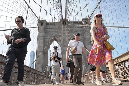 People walk on the Brooklyn Bridge in New York City.