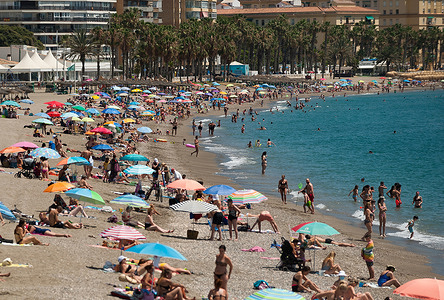 People sunbathing at La Malagueta beach during a hot summer day.
A heatwave crosses the country with high temperatures, according to the Spanish Meteorology Agency.