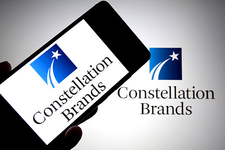 In this photo illustration, the Constellation Brands logo is seen displayed on a smartphone and in the background.