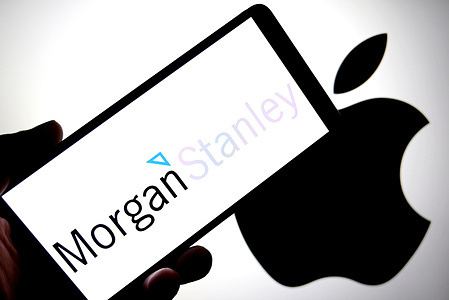 In this photo illustration, the Morgan Stanley logo is seen displayed on a smartphone with an Apple logo in the background.