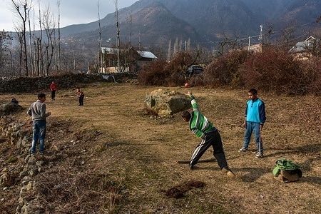 Kashmiri children play cricket in a field on the top of the hill during a sunny winter day. Kashmiris have an immense, deeply ingrained passion for cricket viewing it as an escape, unifying force, and avenue of expression despite significant challenges.