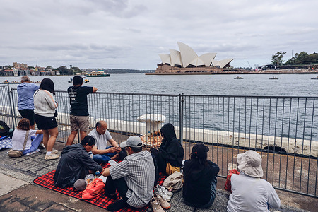 People are seen waiting in front of the Sydney Opera House to watch the Australia Day fireworks. People gather at the Circular Quay Harbour Lookout while waiting for the Australia Day fireworks, as crowds build along Sydney Harbour ahead of the evening celebrations.