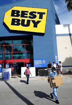 A man carries a television he purchased at a Best Buy store on Black Friday, traditionally one of the busiest shopping days of the year.
 Crowds are smaller this year due to the increasing popularity of on-line shopping amid concerns about the COVID-19 pandemic.