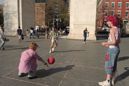 People play with a red ball in Washington Square Park, Manhattan, New York City.
