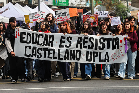 Students carry a banner while marching during a protest against the economic cuts imposed by the government of President Jose Antonio Kast.