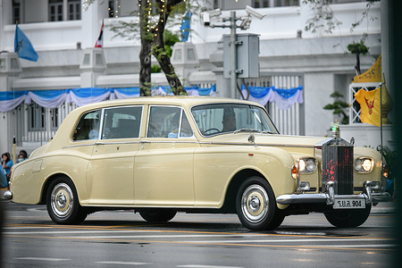 Thailand's King Maha Vajiralongkorn (C) waves as he arrives with Queen Suthida of Thai during Queen Sirikit's 88th birthday celebration at Sanam Luang.