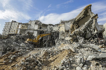 A bulldozer removes debris of Al-Jawharah Tower that was hit by Israeli air strikes during Israel-Palestine fighting in May, 2021.