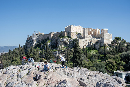 View to the Acropolis of Athens from the Areopagus Hill. The Acropolis of Athens is an ancient citadel located on a rocky outcrop above the city of Athens, Greece, and contains the remains of several ancient buildings of great architectural and historical significance, the most famous being the Parthenon.