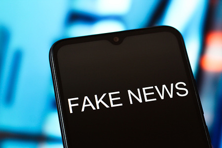 In this photo illustration, the Fake News word is seen displayed on a smartphone screen.